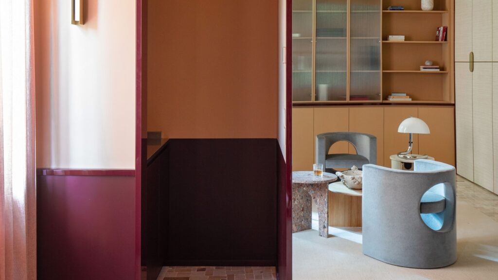Living di T-Rooms a Milano, progetto KICK.OFFICE, con superfici specchianti rosso vino. Foto Giulia Benedetta Costa.